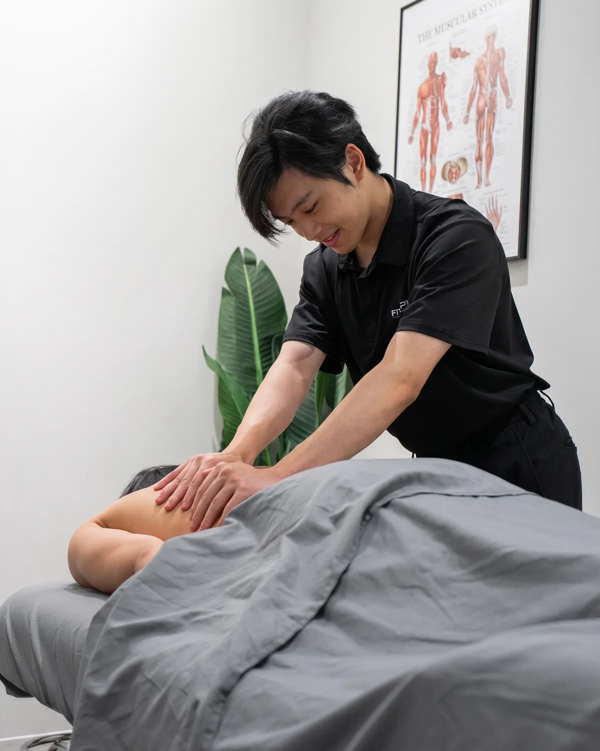A Registered Massage Therapist working on a patient's lower back.